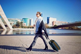 Female Business Traveler With Luggage Walking Outside
